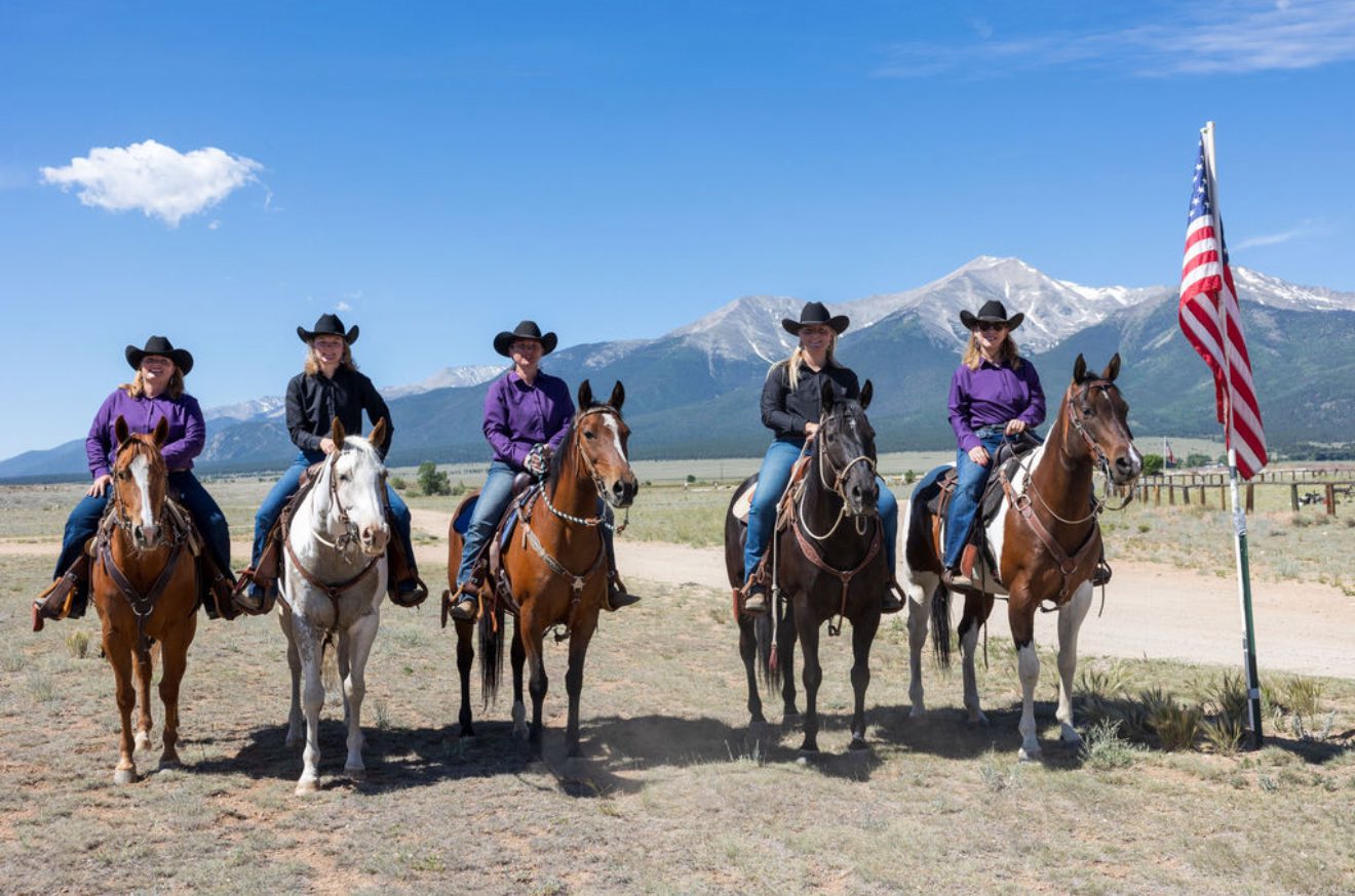 Five Rocky Mountain Freedom Riders mounted with the U.S. flag in front of the Sangre de Cristo mountains